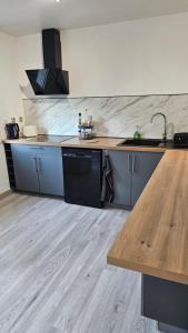 a kitchen with a sink and a wooden counter top at Maison hortensia in Le Cheylard