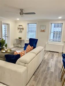 a living room with a white couch and blue chairs at 8th Floor Stylish Downtown Condo Private Balcony in Atlanta