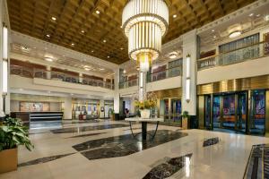 a large lobby with a large chandelier and a table at New Yorker by Lotte Hotels in New York