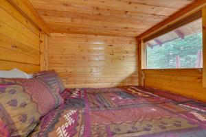 a bed in a log cabin with a window at Ultimate Alaskan Retreat Lakefront Soldotna Cabin in Ridgeway