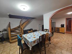 ein Wohnzimmer mit Tisch und Treppe in der Unterkunft Maison près de Genève, CERN, et stations de ski in Péron