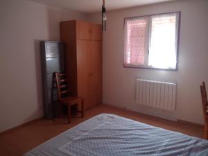 ein Schlafzimmer mit einem Bett, einem Fenster und einem Stuhl in der Unterkunft Maison près de Genève, CERN, et stations de ski in Péron + 3 Fotos