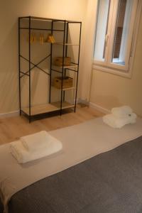 a room with a shelf with towels on a bed at Luminoso Bilbao in Bilbao