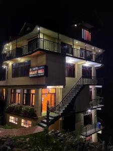 a large building with a staircase in front of it at night at Smart Hill Kalatop, Dalhousie in Dalhousie
