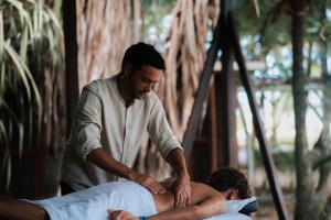 Um homem está massageando outro homem. em Palmar Beach Lodge em Bocas Town