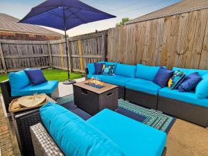 a patio with blue couches and an umbrella at The Stay at Steuben Fire Pit Brand new furniture in Springdale