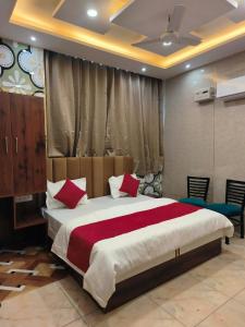 Un dormitorio con una cama grande con almohadas rojas. en Punjabeez Restaurant, en Patiala