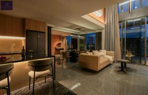 Una cocina y una sala de estar con un sofá y una mesa. en Metropole Saigon Luxury Residence, en Ho Chi Minh