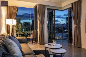 Una sala de estar con un sofá y una ventana grande. en Metropole Saigon Luxury Residence, en Ho Chi Minh