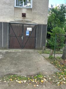a large wooden garage door with a parking sign on it at László Apartman in Debrecen