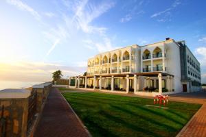 a large white building next to the ocean at Sohar Beach Hotel in Sohar