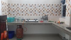 a kitchen counter with a sink and a stove at Peace Abode Vista in Dibrugarh