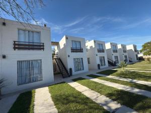 a row of white buildings with grass in front at Hotel La Morada in Treinta y Tres