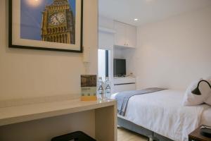a hotel room with a bed and a picture of big ben at Seaside Studio 1BR near the Malecon in Miraflores in Lima