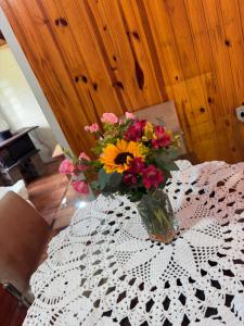 a vase of flowers sitting on a table at Casa da Serra borrussia in Osório +20 photos