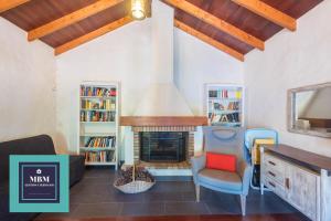 a living room with a fireplace and a chair at Casa Brumas de Arbejales in Teror