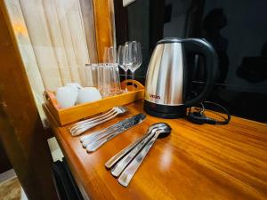 a tea kettle and utensils on a wooden table at Erene Inn in Ella