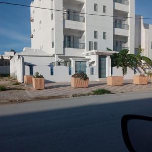 a building on the side of a street with plants at Seaview Apartments in Raoued