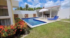a villa with a swimming pool and a house at Elaine Graziela in Pitimbu