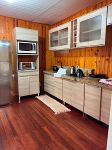 a kitchen with wooden walls and wooden floors at Casa da Serra borrussia in Osório