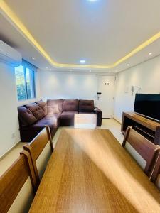 佩洛塔斯Apartamento pelotas的客厅里有一张沙发和一张桌子。