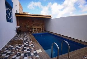 a swimming pool in a building with a tile floor at Reda House in Ikouzza