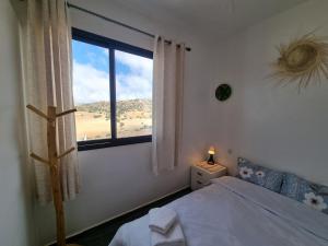 a bedroom with a bed and a large window at Reda House in Ikouzza