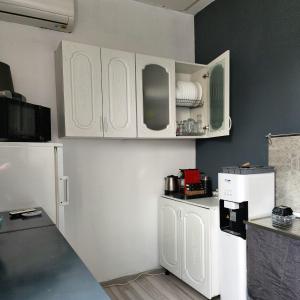 a kitchen with white cabinets and a white refrigerator at The Nomads Nest - Old Town in Bucharest