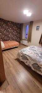 una camera da letto con due letti e un muro di pietra di Appartement 49m2 hyper centre a Gérardmer
