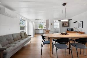 Una sala de estar con un sofá, una mesa y sillas. en SJ309-Bjert-Kystvej-60, en Bjert Strand