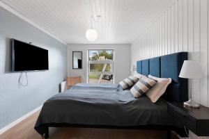 1 dormitorio con 1 cama grande y TV en la pared en SJ309-Bjert-Kystvej-60, en Bjert Strand