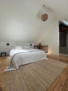 a white bedroom with a large bed with a rug at Yport - Normandy - Casa Eterea 5 in Yport