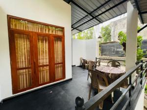 a porch with a wooden door and a table and chairs at Erene Inn in Ella
