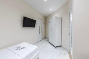 a white room with a bed and a flat screen tv at Bar Hotel Mokador in Shkodër