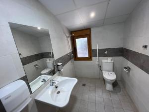 a bathroom with a sink and a toilet and a mirror at Alojamiento Rural La Arboleda in Noviercas