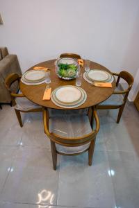 a wooden table with plates and a bowl of food on it at Amazing 2BR apartment near the airport in Los Frailes