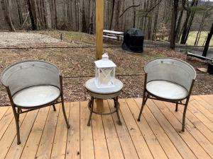 Dos sillas y una mesa con una linterna en una terraza. en A Truly Glamping Experience in this Beautiful Tent in Victor, West Virginia, en Victor 42 fotos más