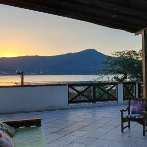 a patio with a view of the ocean and a mountain at Pousada Green in Florianópolis