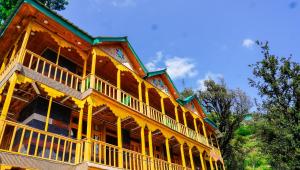 a large wooden building with a green roof at Himalayan Homestay Gadagusain in Jibhi +46 photos