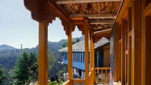 a view from the balcony of a house with mountains in the background at Himalayan Homestay Gadagusain in Jibhi