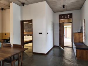un soggiorno con un tavolo e una camera da letto di Birdwing - Experiential Farmstay Resort by GoodEarth 