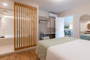 sypialnia z łóżkiem i wanną w obiekcie LF PARKING INCLUIDO Amplio Loft en Barrio Santa Cruz w Sewilli