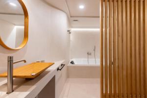 W łazience znajduje się drewniana umywalka i wanna. w obiekcie LF PARKING INCLUIDO Amplio Loft en Barrio Santa Cruz w Sewilli