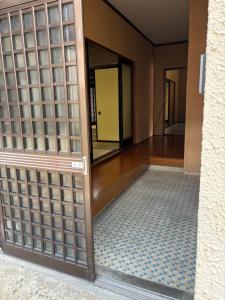 una entrada a una habitación con puerta de cristal en Guesthouse今井邸, en Tonami