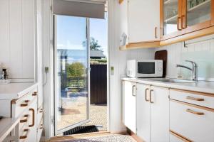 a kitchen with a door leading to a patio at LF14058-Roslev-Eskovvej-58 in Flovtrup