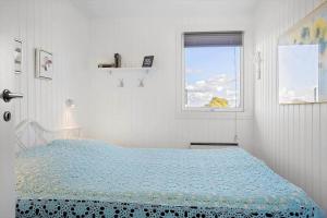 a white bedroom with a bed and a window at LF14058-Roslev-Eskovvej-58 in Flovtrup