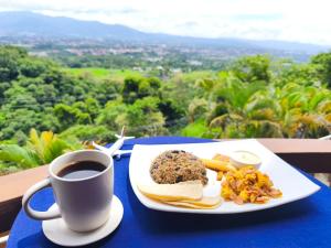 een bord eten en een kopje koffie op een tafel bij Hotel Mirador Mayday Mountain View in Alajuela +70 foto's