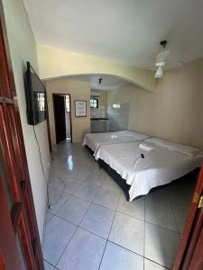a bedroom with a large bed in a room at Villa Palmeiras Suítes in Cabo Frio +43 photos