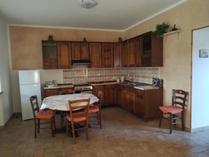 a kitchen with wooden cabinets and a table and chairs at La Coccinella in Canale Monterano