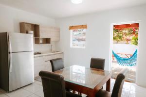 a kitchen with a dining table and a refrigerator at Casa del Sol, 2-Bedroom Home Near Palm Beach in Noord